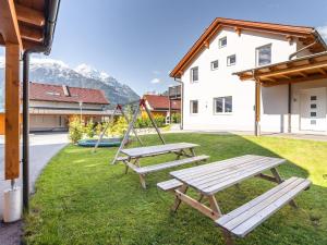 2 Picknicktische und eine Schaukel im Hof in der Unterkunft Chalet in Koetschach-Mauthen in Carinthia in Kötschach
