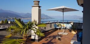 a balcony with an umbrella and a lighthouse at Terrace Lake View in Stresa