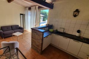 a kitchen with a sink and a couch in a room at Gîte Les Grillons in Draguignan