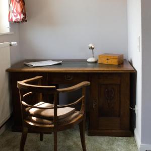 a wooden desk with a chair and a lamp at Ferienwohnung Reinette in Lippoldsberg