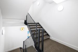 a staircase with black railings and white walls at 2 Bedroom Luxury Apartments with Parking in Stanmore, North West By 360 Stays London in Stanmore