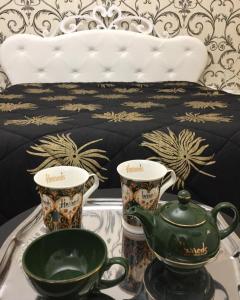 a table with a tea pot and two cups on a bed at Il giardino in Canicattì