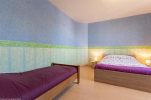 a bedroom with a bed and blue walls at Les Hirondelles in Pesmes