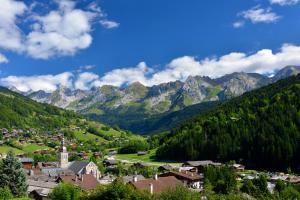 a town in a valley with mountains in the background at Studio Danay Accès Espace Détente Gratuit in Le Grand-Bornand