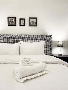 a bedroom with a white bed with towels on it at SOHO Modern 55sqm Studio with Secret Garden in Athens