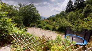 a hot tub in a cage next to a river at L'Horizon - Maison en Pierres, Vue Alpes et Nature in La Burbanche +49 photos