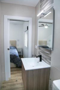 a bathroom with a sink and a mirror and a bed at La Casa de Alarcón in Alarcón