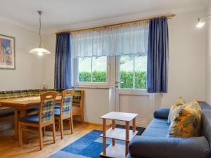 ein Wohnzimmer mit einem Tisch und einem blauen Sofa in der Unterkunft Modern apartment in Salzburger with terrace in Kleinarl