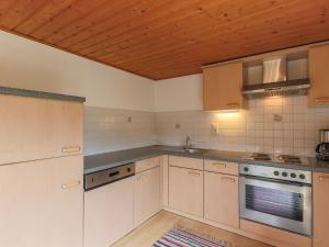 a kitchen with white cabinets and a wooden ceiling at Cosy holiday home near ski area in Piesendorf