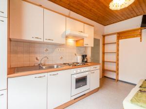 a kitchen with white cabinets and a sink at Apartment in Tr polach Carinthia with pool in Tröpolach