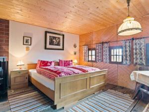 a bedroom with a bed with red pillows at Holiday home in Arriach near a swimming lake in Arriach