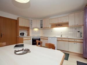 バルトロメベルクにあるRadiant Holiday Home in Gantschier with Terraceの白いキャビネット、テーブルと椅子付きのキッチンが備わります。