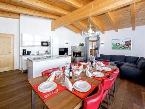 ゲルロスにあるSpacious Apartment in Gerlos near Ski Areaのダイニングルーム(テーブル、赤い椅子付)