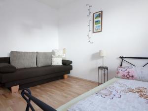 uma sala de estar com um sofá e uma cama em Nice apartment at Sonnenkopf in a natural paradise em Dalaas