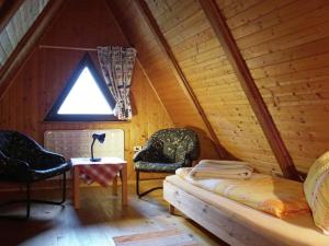 JenigにあるHoliday home in Jenig Carinthia with poolのベッド1台と椅子2脚が備わる屋根裏部屋です。