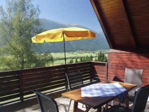 a table and chairs with an umbrella on a balcony at Holiday home in Jenig Carinthia with pool in Jenig