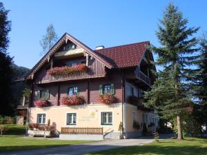 a large house with flowers on the windows at Renovated holiday home in the mountains in Pruggern