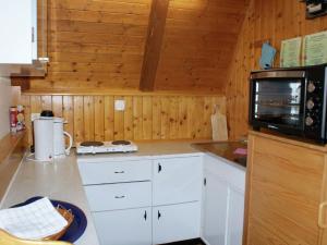 JenigにあるHoliday home in Jenig Carinthia with poolのキッチン(白いキャビネット、電子レンジ付)