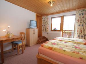 a bedroom with a bed and a desk and a television at Splendid Apartment in Schladming with Sauna in Schladming