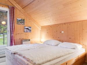 a bedroom with a bed in a wooden cabin at Chalet in St Georgen ob Murau with sauna in Sankt Georgen ob Murau