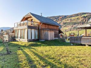 a wooden house on a grassy field in front at Chalet in St Georgen ob Murau with sauna in Sankt Georgen ob Murau