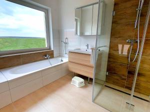 a bathroom with a tub and a sink and a window at Ferienhaus XL in Lutzmannsburg