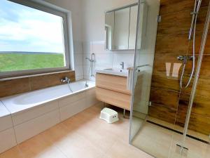 ein Bad mit einer Badewanne, einem Waschbecken und einem Fenster in der Unterkunft Ferienhaus XL in Lutzmannsburg