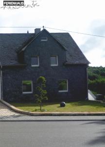 ein Haus mit einem Baum davor in der Unterkunft Ambiente in Mehren