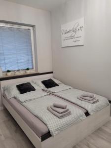 1 dormitorio con 2 camas y toallas. en Apartament Piątka en Płock