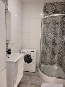ein weißes Badezimmer mit einer Waschmaschine und einer Waschmaschine in der Unterkunft Apartament Piątka in Płock