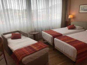 pokój hotelowy z 2 łóżkami i oknem w obiekcie Crystal Hotel Varese w mieście Varese