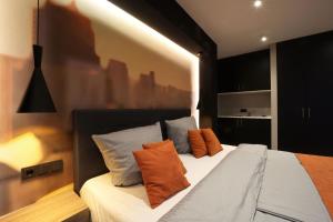um quarto com uma cama com almofadas laranja e azul em JustStay Ratingen em Ratingen