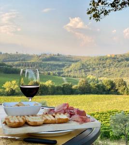 une assiette de nourriture et un verre de vin dans l'établissement Agriturismo La Valle A Polvereto, à Tavarnelle in Val di Pesa
