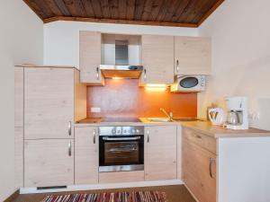 a kitchen with wooden cabinets and a stove top oven at Lush Apartment in Afritz am See near Ski Area in Afritz