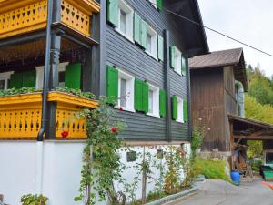 シュルンスにあるCozy Apartment near Ski Area in Tschaggunsの緑黄のシャッター付きの建物