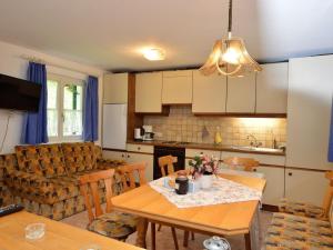 een keuken en een woonkamer met een tafel en een bank bij Cozy Apartment near Ski Area in Tschagguns in Schruns