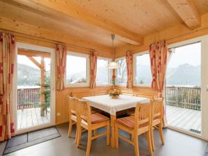 a dining room with a table and chairs and windows at Chalet in Hohentauern near ski area in Hohentauern