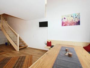 Cette chambre dispose d'une table en bois et d'une peinture murale. dans l'établissement Holiday home Steinfeld close to the ski lift, à Zell am Ziller