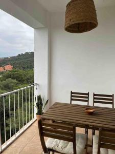 una mesa de madera y sillas en un balcón con vistas en Apartamento en Playa de Pals con encanto y vistas en Pals