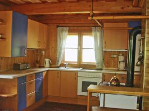 a kitchen with wooden cabinets and a window at Inviting Chalet in Kolbnitz Teuchl with Garden and Terrace in Penk