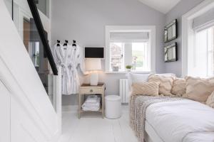 a white living room with a couch and a table at Lower Arthur's Cottage in Saddleworth, Manchester in Oldham