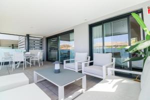 salon z białymi krzesłami i stołem w obiekcie Brand new luxury apartment in Cala Serena w mieście La Cala de Mijas