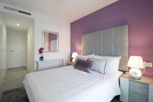 sypialnia z dużym białym łóżkiem i fioletowymi ścianami w obiekcie Brand new luxury apartment in Cala Serena w mieście La Cala de Mijas +35 zdjęć