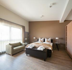 sypialnia z łóżkiem, krzesłem i oknem w obiekcie Boarding Haus Aachen-Brand w Akwizgranie