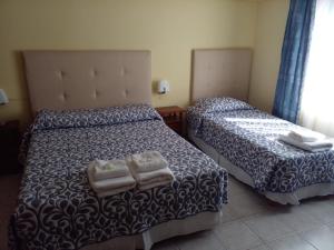two beds in a room with two lamps at Calafate Hostel in El Calafate