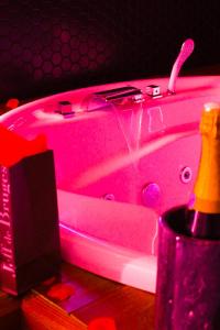 a pink bathtub with pink lights on it at Seasides Paris - Suite Monroe in Le Blanc-Mesnil