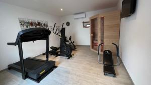 um quarto com ginásio com passadeira e equipamento de exercício em Le patio d'Oscar em Failly