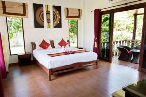 a bedroom with a large bed in a room with windows at Banburi Villa - 4 Bedroom Private Pool Villa in Krabi town +56 photos