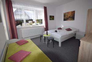 ein Schlafzimmer mit 2 Betten und einem Tisch darin in der Unterkunft Pension St. Moritz in Železná Ruda