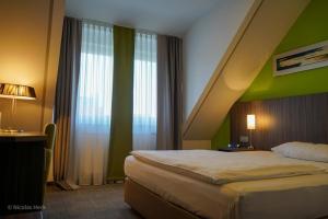 - une chambre avec un lit et un mur vert dans l'établissement Hotel Ambiente Walldorf, à Walldorf